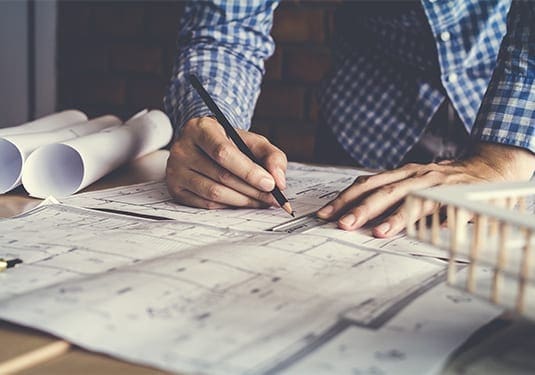 Architect working on technical drawings during the design and planning stage.